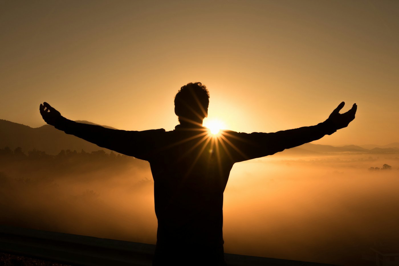 Personne les bras ouverts face au lever du soleil