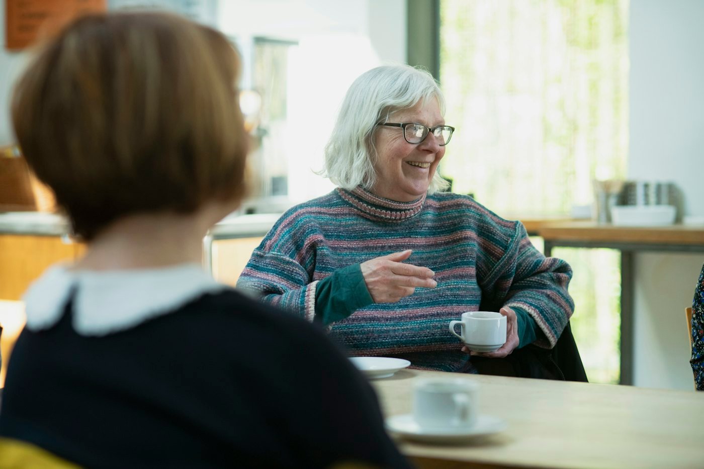 Une femme souriante au sein d'un groupe de discussion
